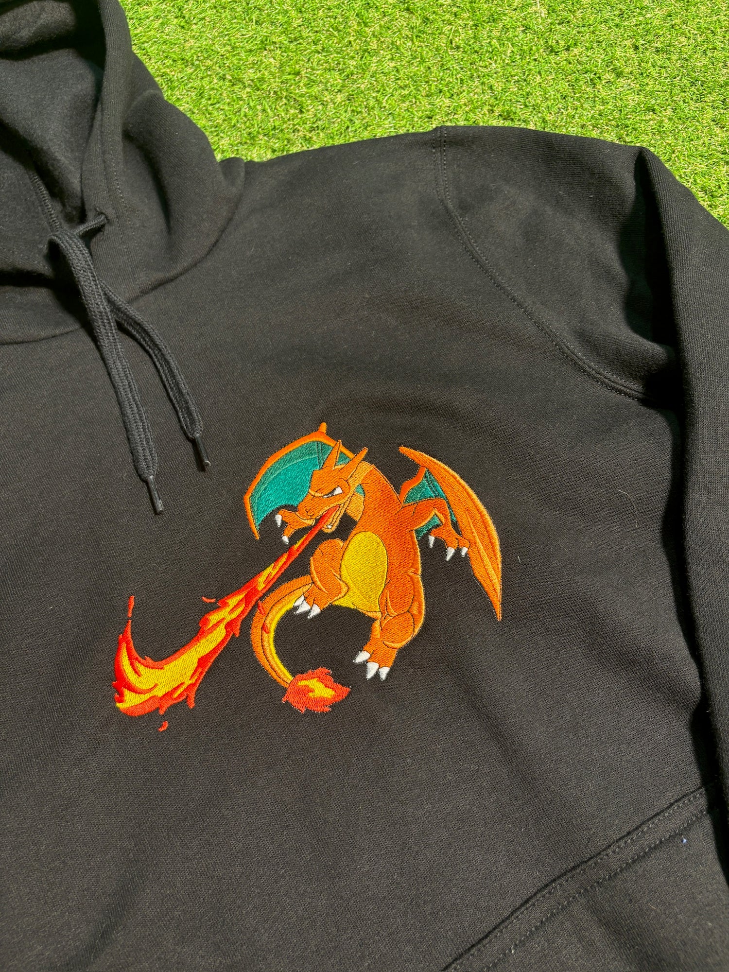 pull noir avec une broderie de dracofeu au centre
